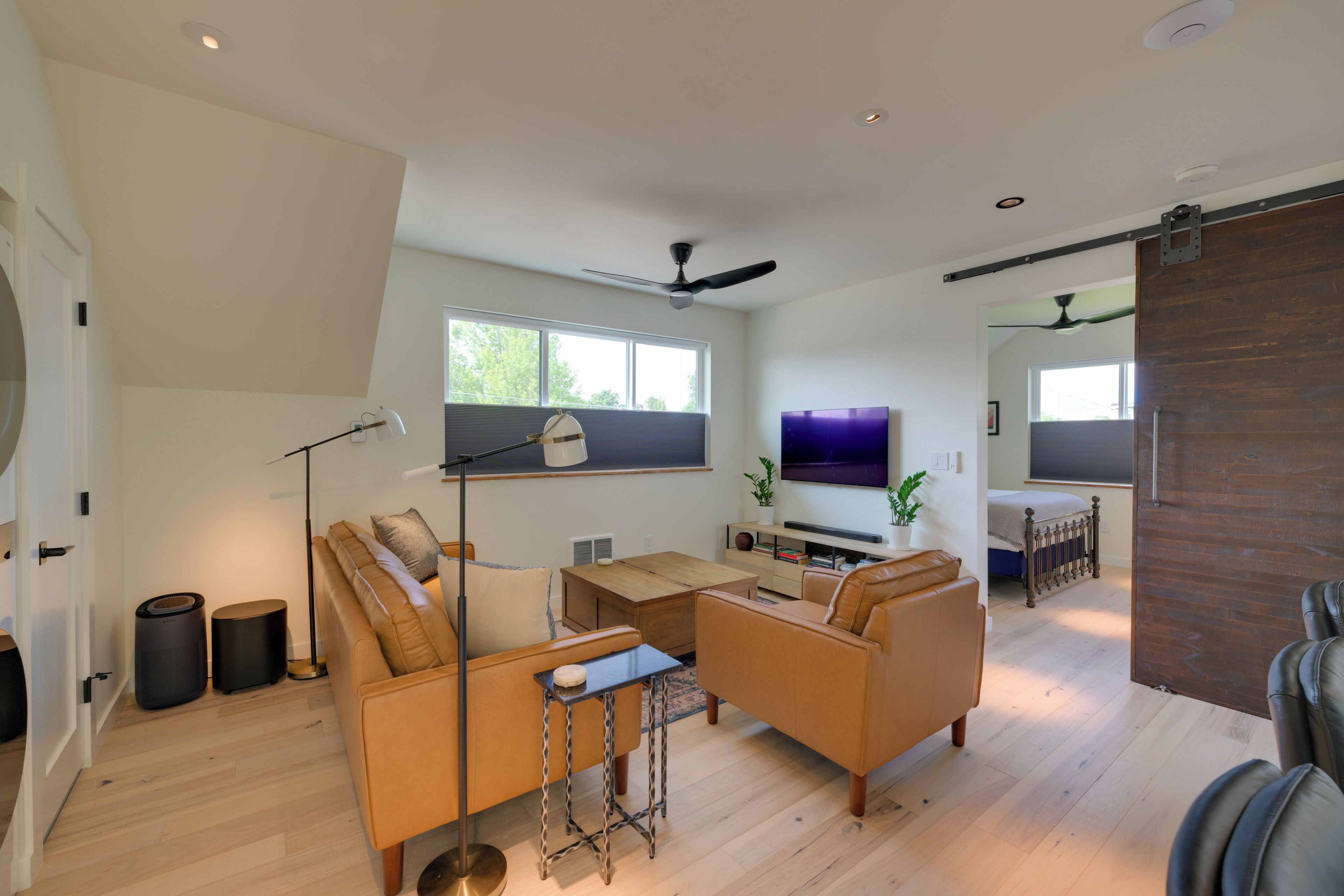 A spacious living room with a sofa set, a coffee table, and a TV.