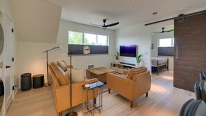 A spacious living room with a sofa set, a coffee table, and a TV.