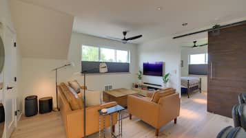 A spacious living room with a sofa set, a coffee table, and a TV.
