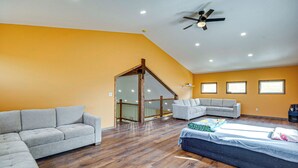 A spacious room with a sloped ceiling, a ceiling fan, and a large window. - Mtn-view Deck! Remote South Park Retreat (Hartsel)