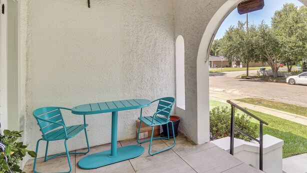 A patio with a table and chairs, a view of the street, and a railing. - Walk to Gulfport Beach! Quiet Home w/ Yard (Gulfport)