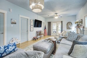 Ein geräumiges Wohnzimmer mit einer großen Sofagarnitur, einem Holztisch und einer Deckenleuchte.
