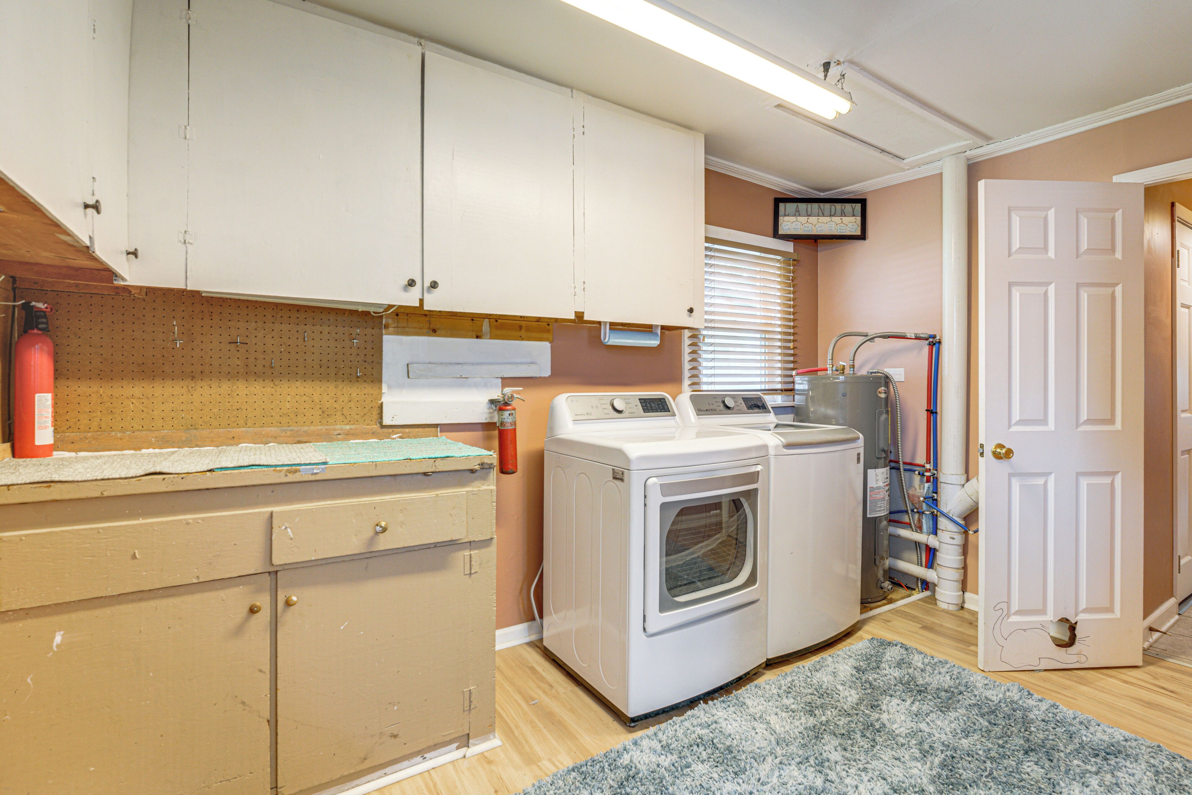 A laundry room with a washing machine, dryer, and a utility sink.