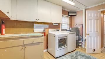 A laundry room with a washing machine, dryer, and a utility sink.