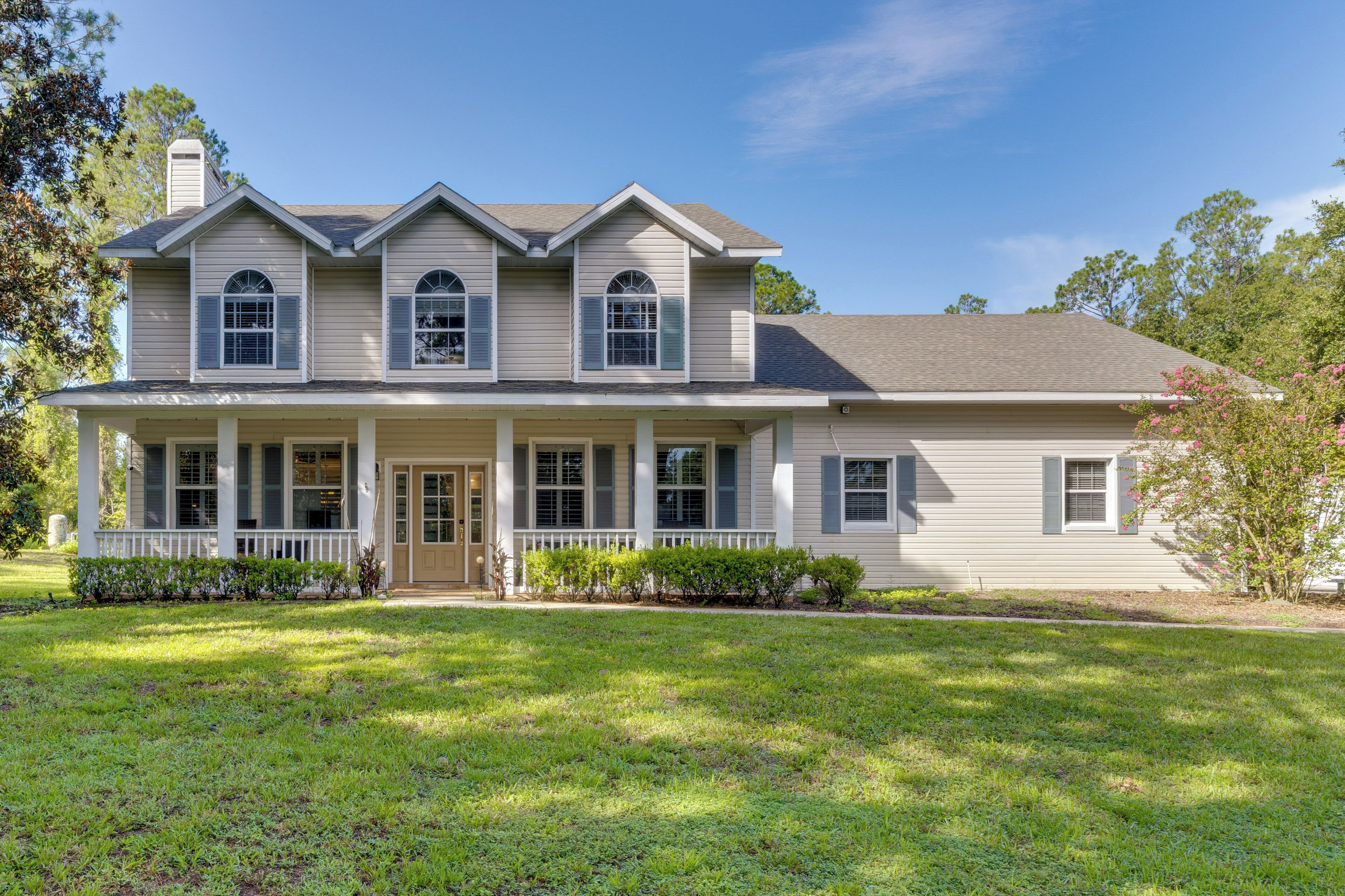 A two-story house with a front porch, multiple windows, and a well-maintained lawn.