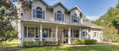 A two-story house with a porch, multiple windows, and a well-maintained lawn.
