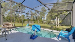 A covered outdoor swimming pool with lounge chairs and a hot tub. - Pool, Patio + Game Room! Secluded Montverde Home (Montverde)