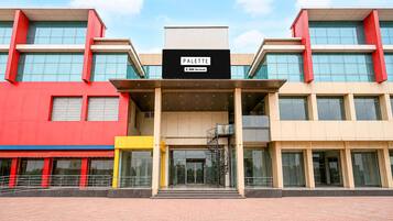 Un edificio moderno con un letrero que dice 'PALETTE' y 'OYO-SERVICED'.