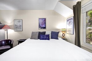 A hotel room with a bed, a chair, a desk, a lamp, and two framed pictures on the wall. - King Bed Studio, Free Shuttle to Slopes & Main Street - Moose Mgmt 425 (Park City)