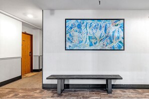 A hallway with a bench, a wooden door, and a large abstract painting on the wall. - King Bed Studio, Free Shuttle to Slopes & Main Street - Moose Mgmt 425 (Park City)