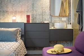 A modern bedroom with a bed, a vanity with a mirror, and a bedside table. - Perseus Apartment near the Colosseum – A stylish stay in the heart of Rome (Roma)