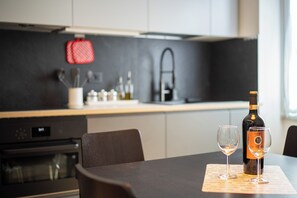 Eine moderne Küche mit Esstisch für zwei Personen, komplett mit einer Weinflasche und zwei Gläsern.