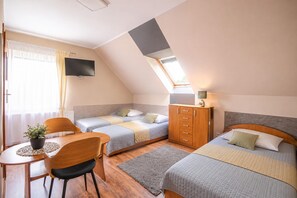 A compact room with two beds, a desk, a chair, a TV, and a wardrobe. - Studio for 4 People, Close to the sea (Kamien Pomorski)