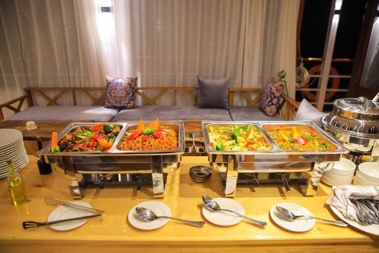 Una mesa de buffet con diversos alimentos y cubiertos.