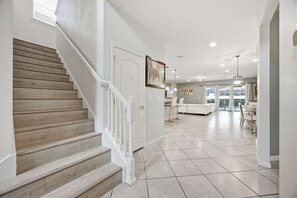 A staircase with wooden steps and white railings leading to a room with a white door. - Windsor Paradise | 8BR Resort Villa Near Disney (Kissimmee)