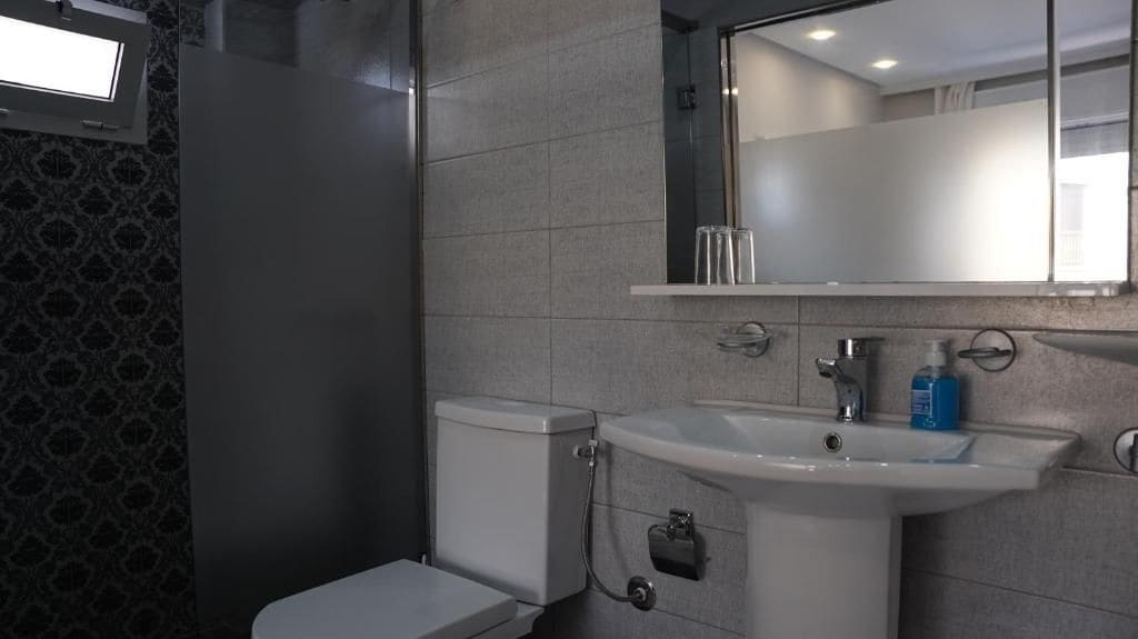 Une salle de bain avec des toilettes, un lavabo et un miroir.