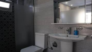 Une salle de bain avec des toilettes, un lavabo et un miroir.