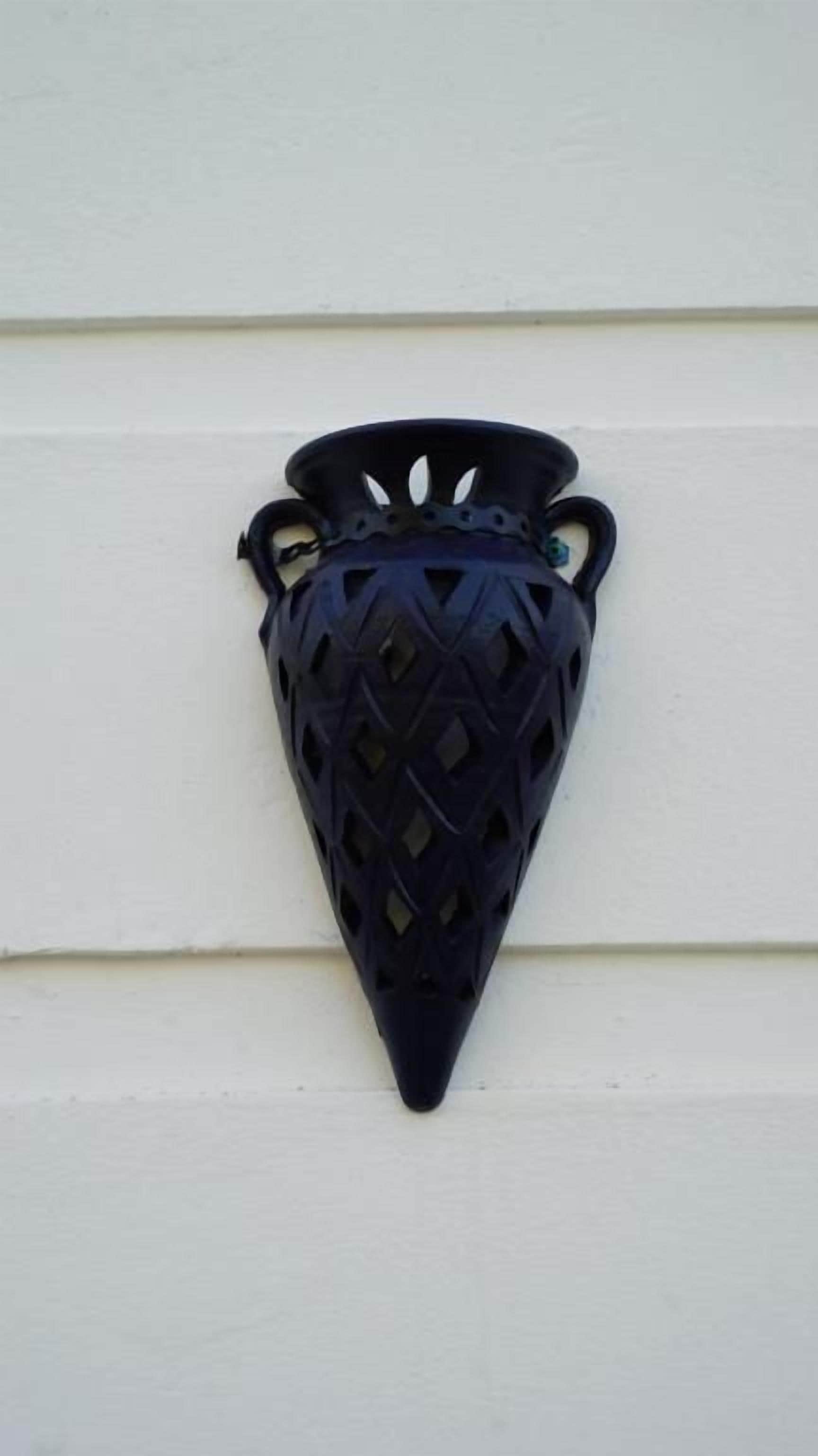 A black, textured wall-mounted light fixture with a conical shape and two handles.