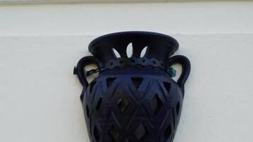 A black, textured wall-mounted light fixture with a conical shape and two handles.