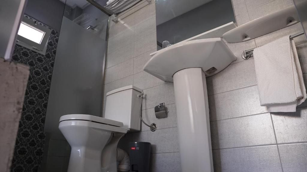 Un baño con inodoro, bidé y perchero para toallas.