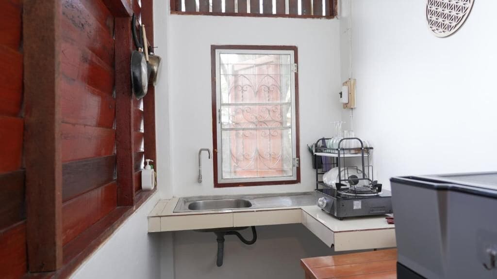 A compact kitchen with a sink, a window, and a small countertop.