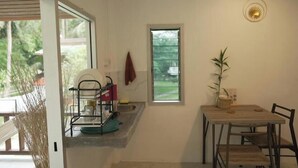 Una cocina con comedor, una ventana y una planta.