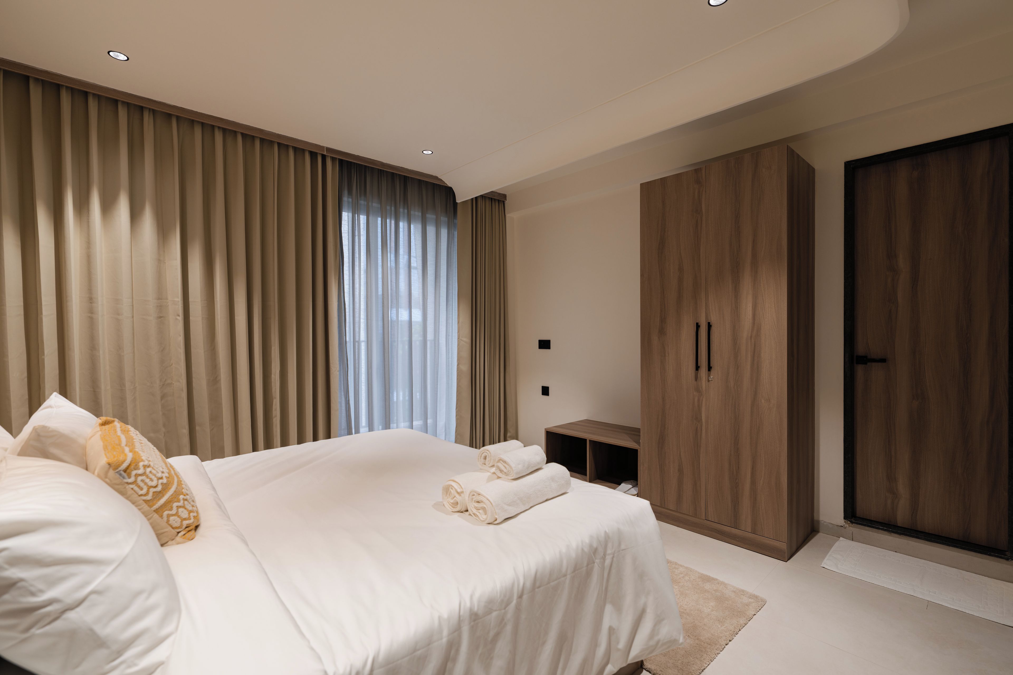 Une chambre moderne avec un grand lit, une armoire et un bureau.