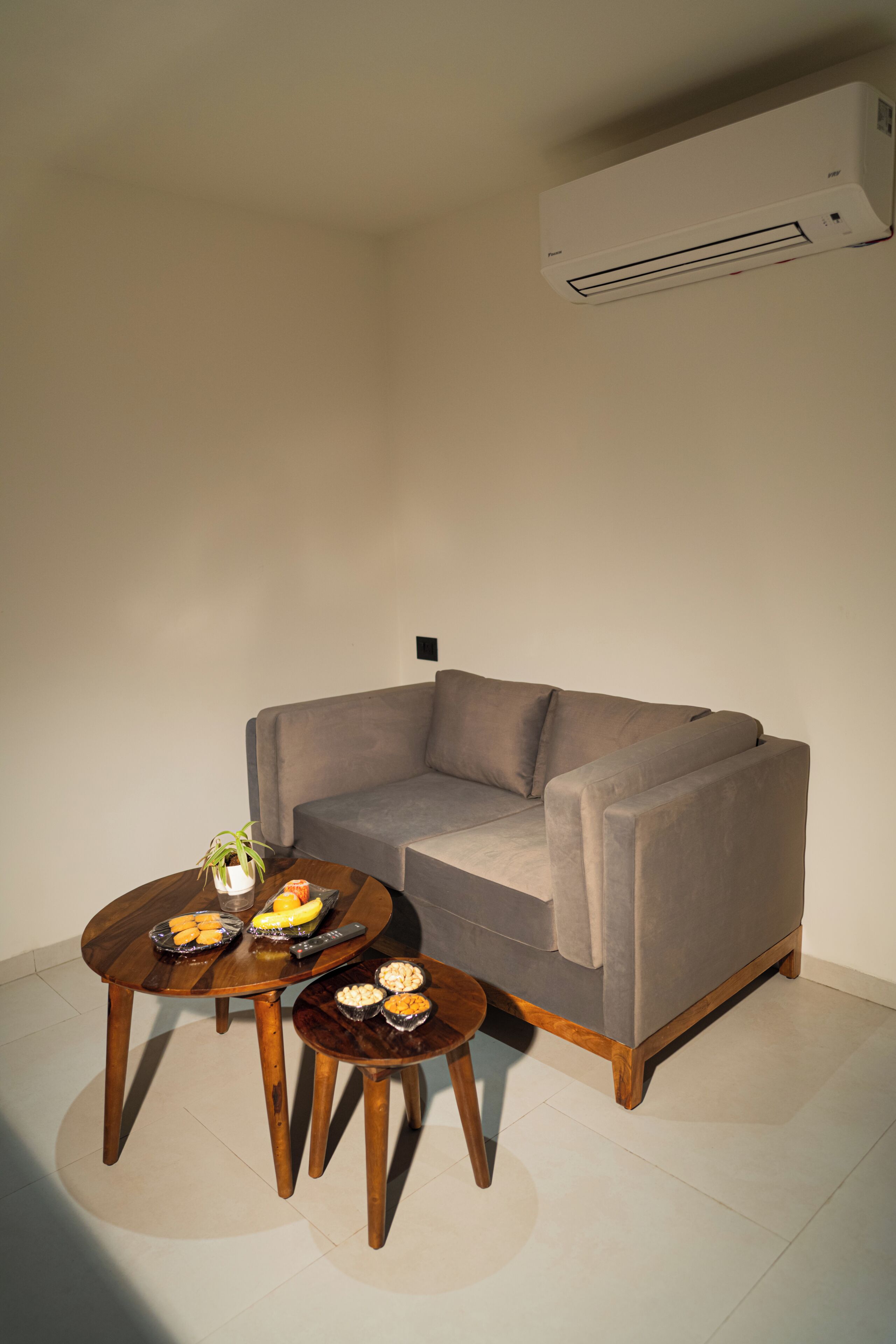 Una sala de estar con sofá, mesa de centro y una mesita auxiliar.