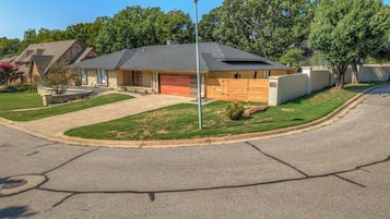 Ein Wohnhaus mit Garage, Auffahrt und einer Straßenlaterne.