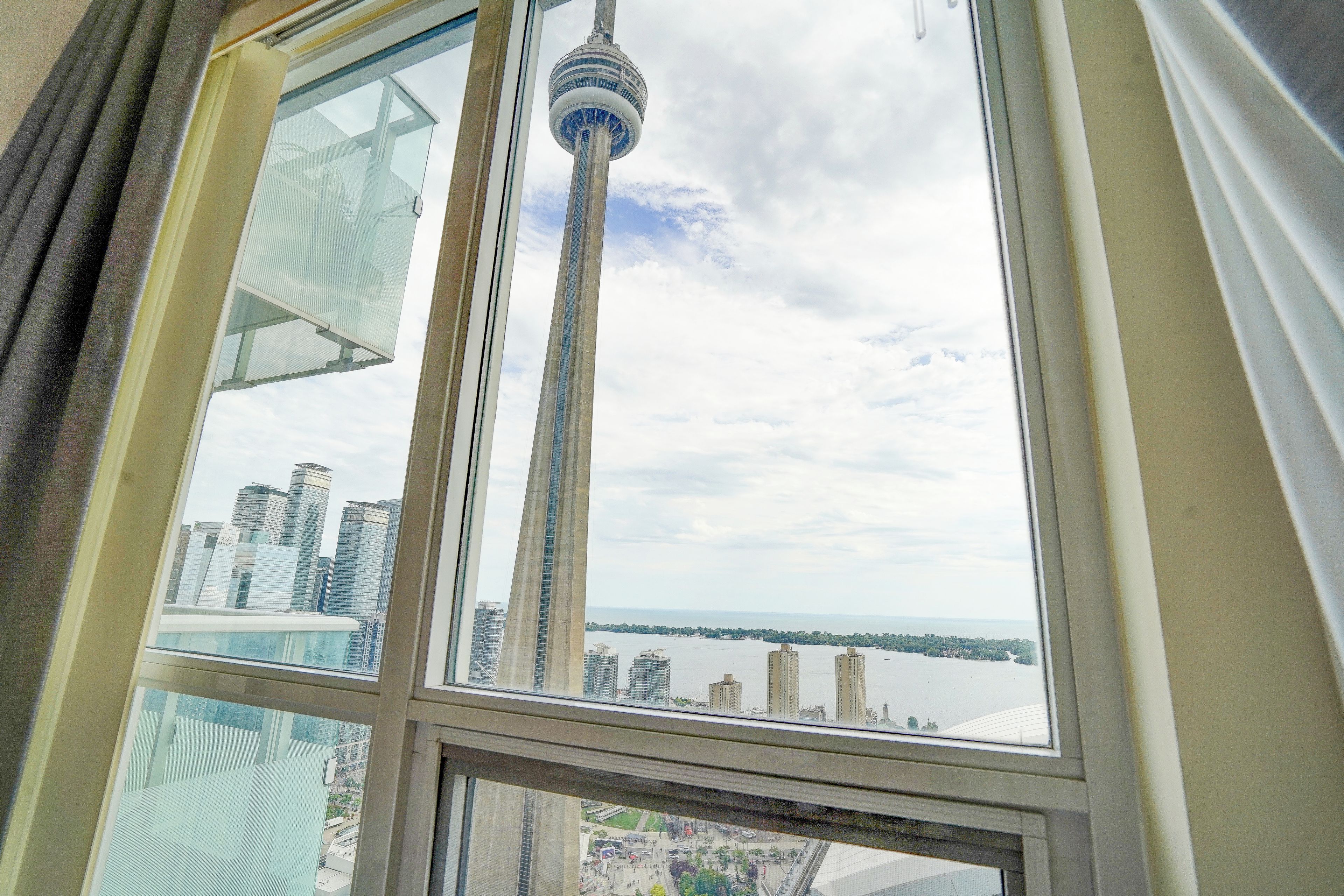 A high-rise building with a view of a tower and a body of water.