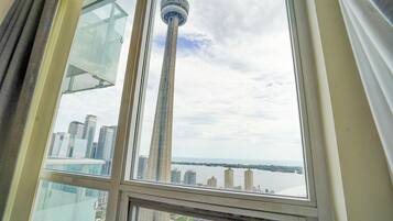 A high-rise building with a view of a tower and a body of water.