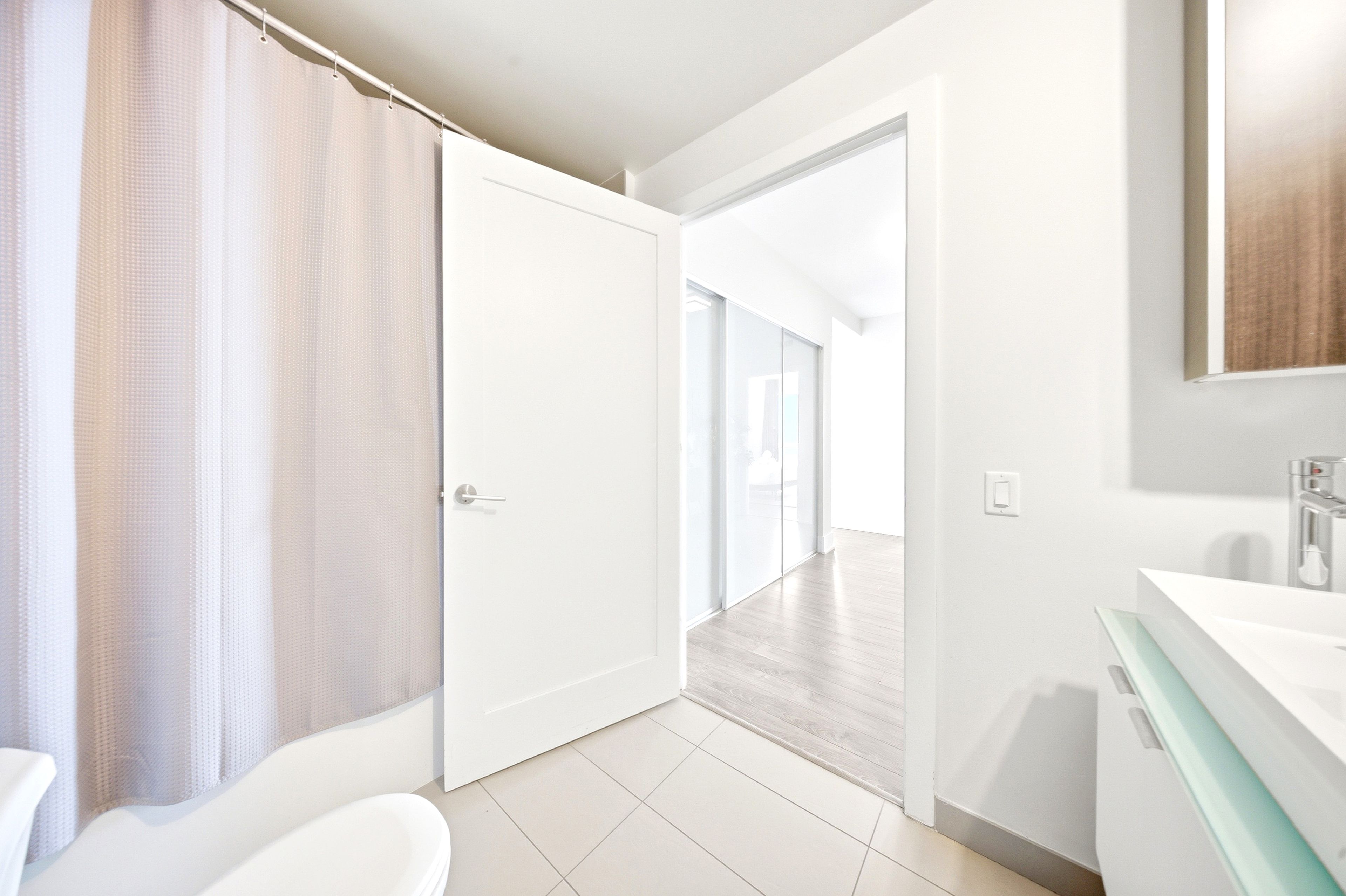 A modern bathroom with a bathtub, a shower, a toilet, a sink, and a mirror.