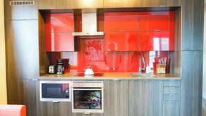 Une cuisine moderne équipée d’appareils électroménagers intégrés, d’un four à micro-ondes, d’un four et d’une machine à café.