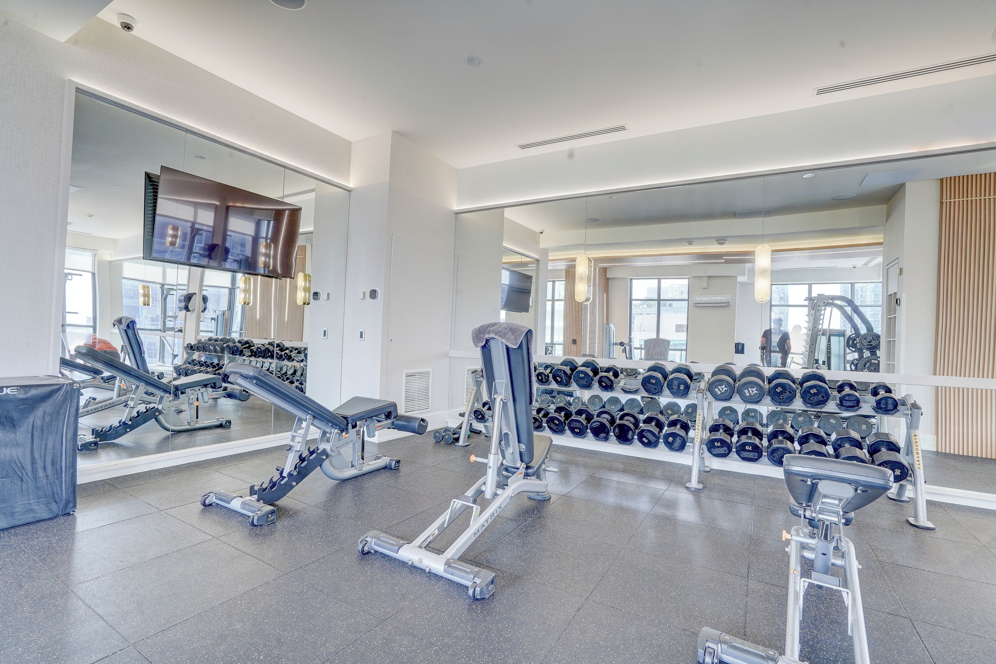 Une salle de sport équipée de divers appareils d’exercice, notamment des tapis de course et des haltères.