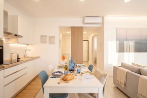 Eine moderne Küche mit Essbereich, einer Couch und Blick auf die Stadt.
