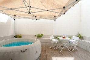 A hot tub under a canopy, a table with chairs, and potted plants. - ALL Spa and Relax | Mediterranean Retreat (Monopoli)
