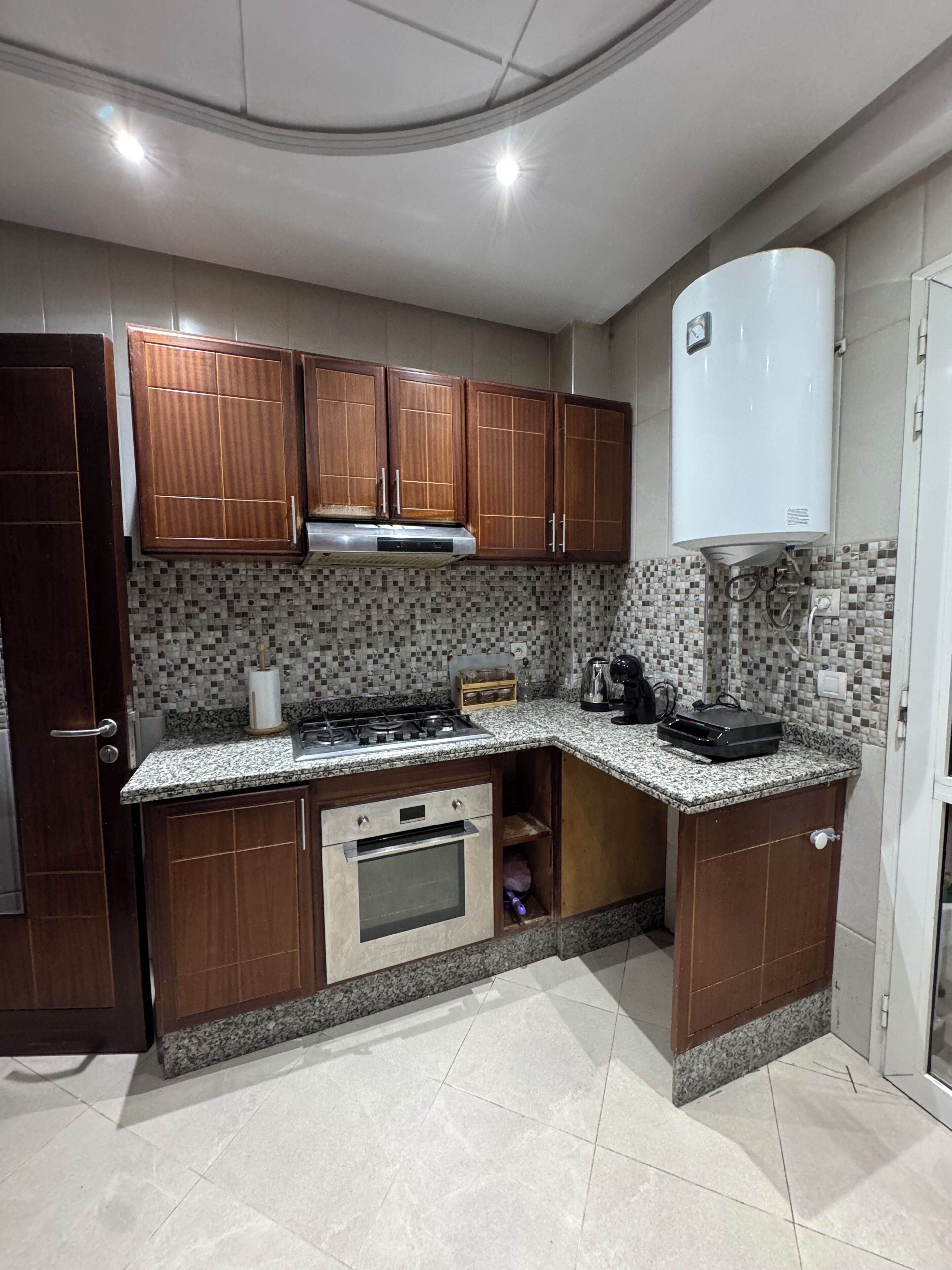 A kitchen with wooden cabinets, a built-in oven, a gas stove, and a microwave.
