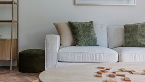 Un salón con sofá, reposapiés y una mesa de centro con bloques.