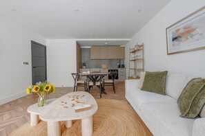 Un salon moderne comprenant un canapé, une table basse et un coin repas avec des chaises et une table.