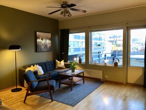 A modern living room with a sofa, armchair, coffee table, and a ceiling fan. - Apartment in the middle of Tromsø City (Tromsø)