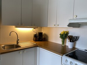 A kitchen with a sink, stove, and cabinets. - Apartment in the middle of Tromsø City (Tromsø)