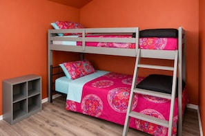 A bunk bed with a ladder, a small shelf unit, and a patterned bedspread. - Lakefront Escape on Twin Lake Cabin + Trailer (Twin Lake)