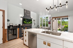 A modern kitchen with a large island, built-in appliances, and a view of the outdoors. - Big Island Waikoloa Colony Villas 2303 2 Bedroom Condo (Waikoloa)