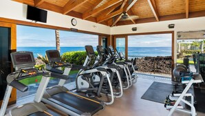 Una palestra con tapis roulant, cyclette e vogatore, con vista sull'oceano.
