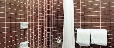A bathroom with a shower, white tiles, and a towel rack with two towels.