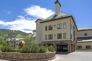 A two-story building with a stone facade and multiple windows. - Charter At Beaver Creek E160 2 Bedroom Condo (Avon)