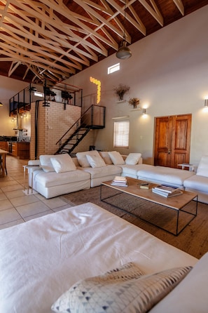 A spacious living area with a large sectional sofa, a coffee table, and a staircase leading to an upper level. - Spacious 3-bedroom home in Stellenbosch (Stellenbosch)