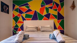 A bed with striped bedding, two pillows, and two rolled towels. - Spacious 3-bedroom home in Stellenbosch (Stellenbosch)