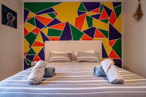 A bed with striped bedding, two pillows, and two rolled towels. - Spacious 3-bedroom home in Stellenbosch (Stellenbosch)