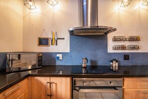 A modern kitchen with a stainless steel range hood, a microwave, a kettle, and a spice rack. - Spacious 3-bedroom home in Stellenbosch (Stellenbosch)